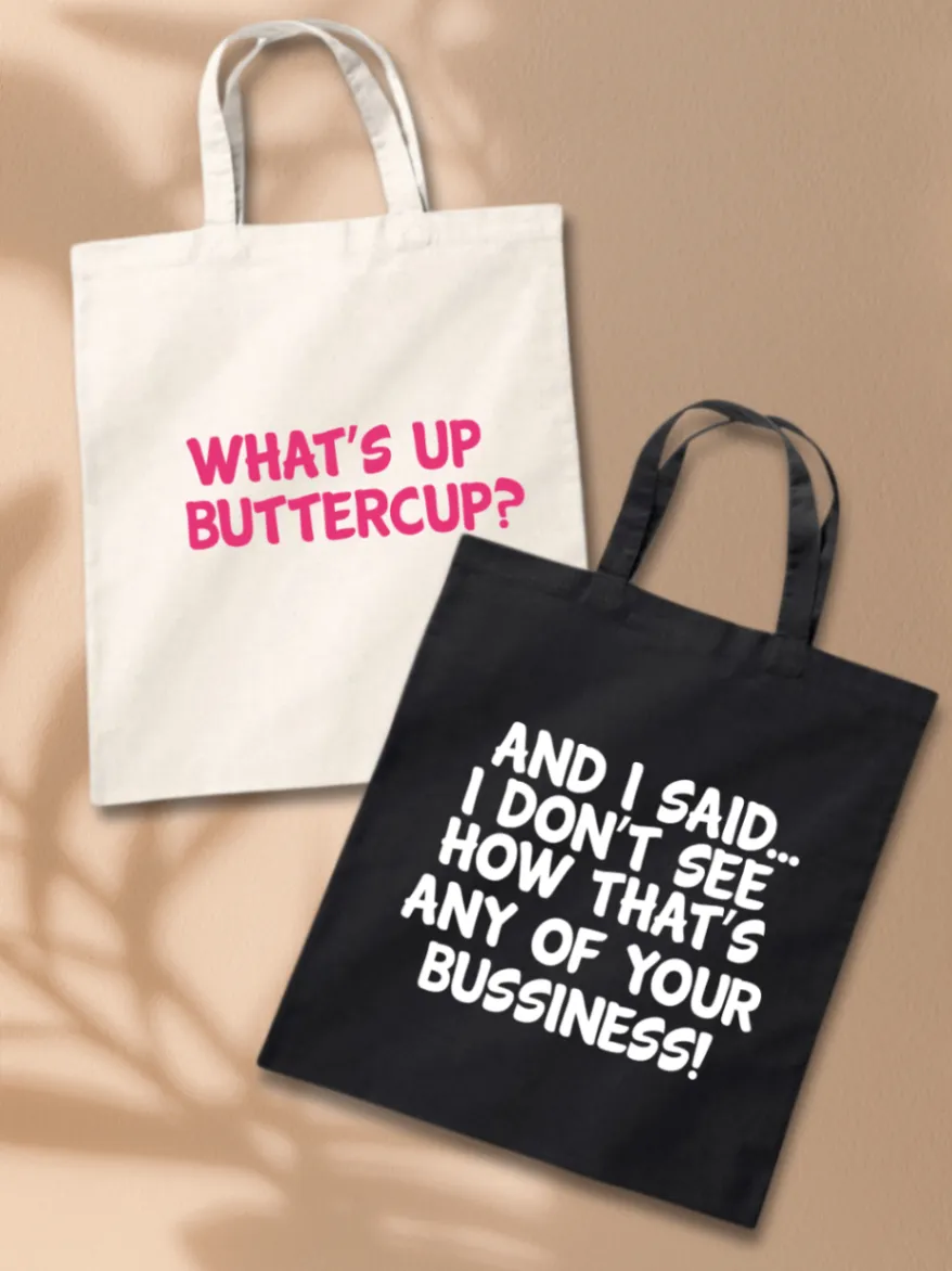 White tote bag printed with pink WHAT'S UP BUTTERCUP? lettering beside a black tote bag with white custom lettering