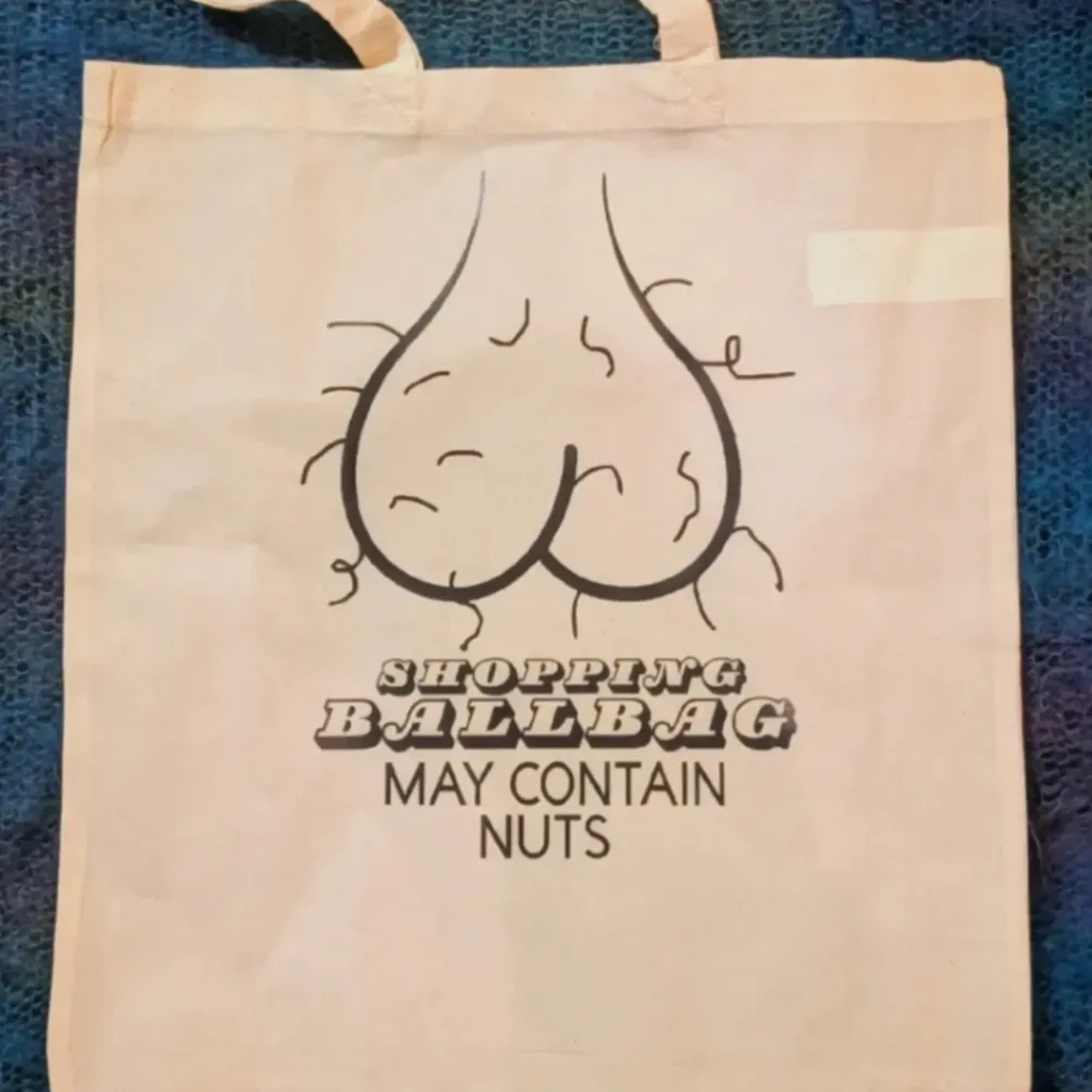 Cream tote bag with a playful line drawing and custom Shopping Ballbag slogan