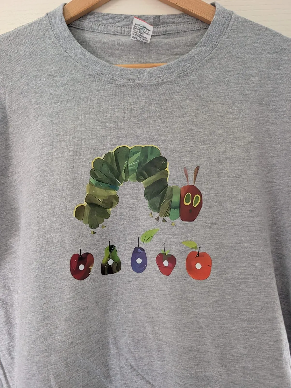 Grey T-shirt with a colourful Caterpillar character and fruit design